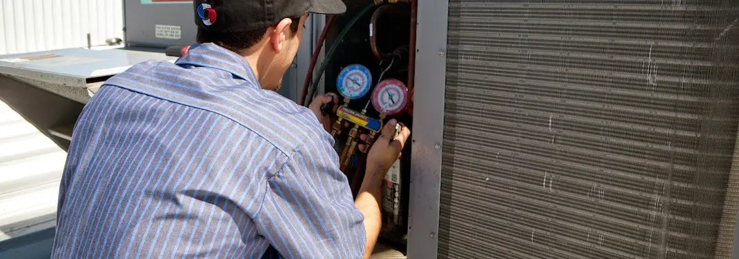 HVAC technician servicing a condenser unit in Rosenberg