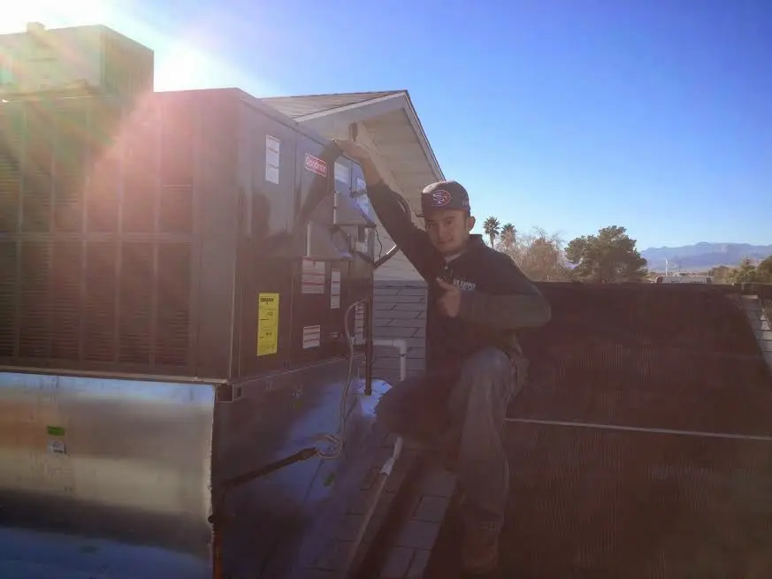 HVAC technician performing HVAC Inspection on a rooftop unit in Rosenberg